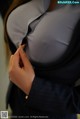 A woman in a business suit is putting on her shirt.