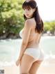 A woman in a white bikini standing on a beach.