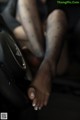 A woman sitting in a car with her feet on the steering wheel.